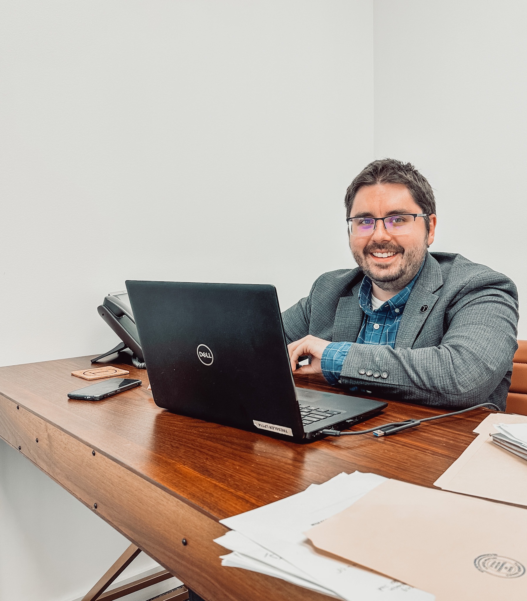 Estate planning attorney Turner Smith Evans sitting at his desk with his laptop and files smiling