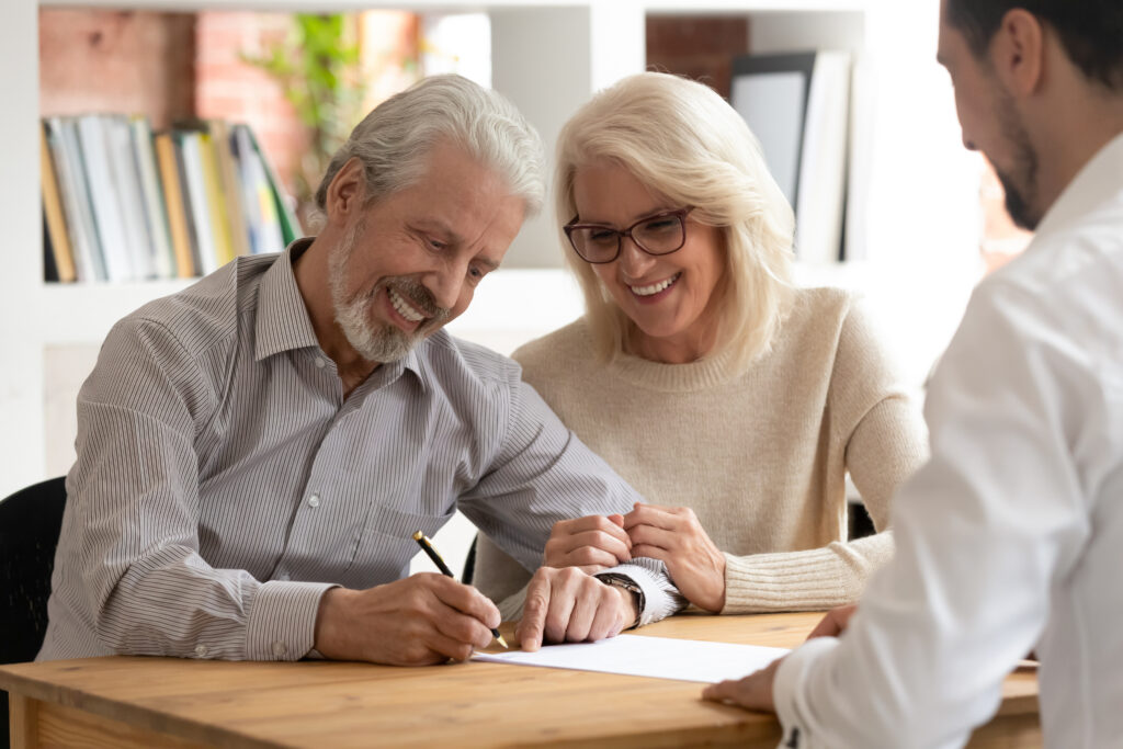 Retired couple signing documents with an estate planning attorney