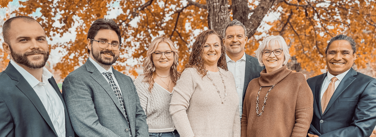 Tressler team posing together outside under a tree